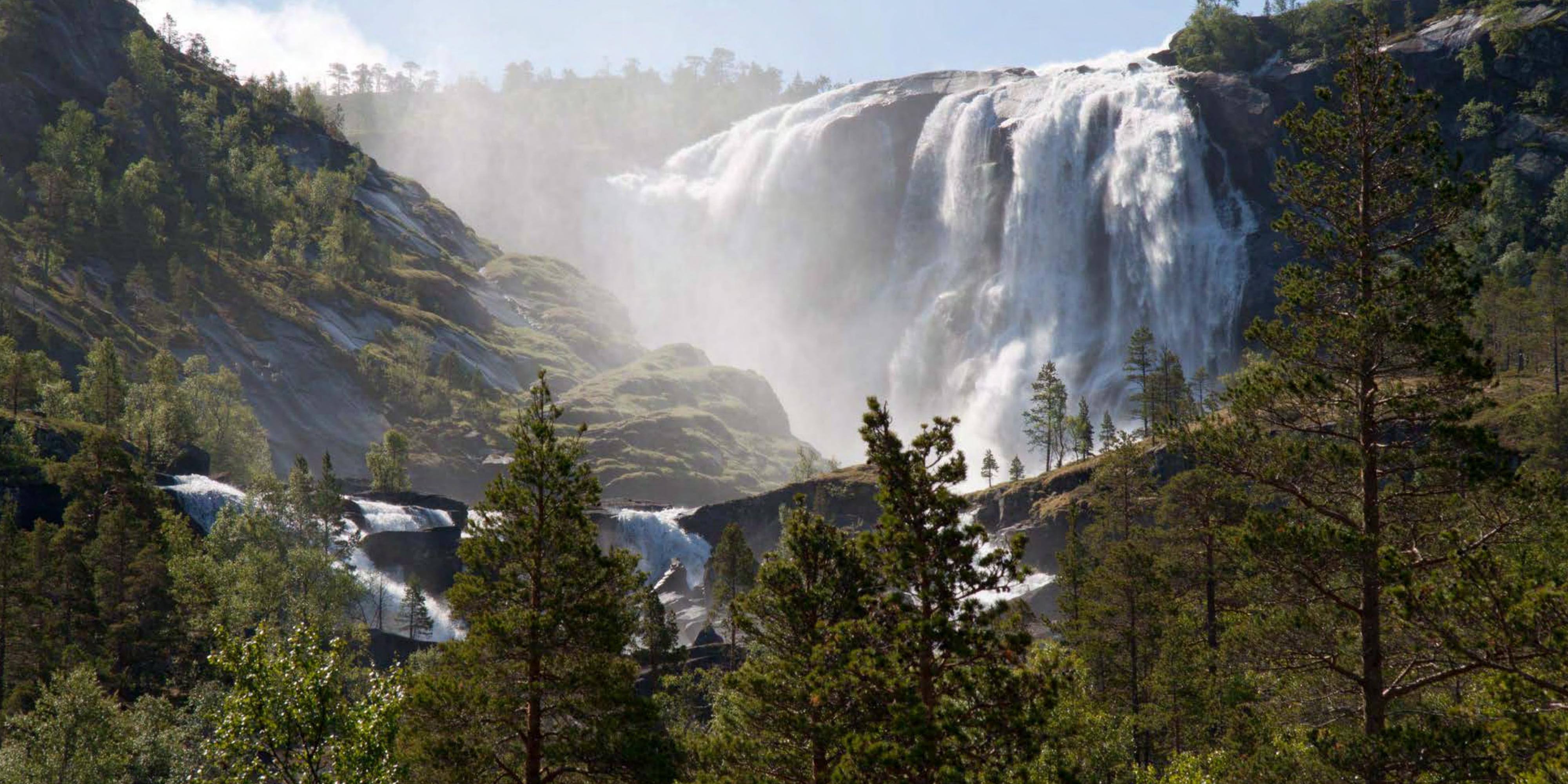 A waterfall pouring over granite slabs on the Norwegian coast